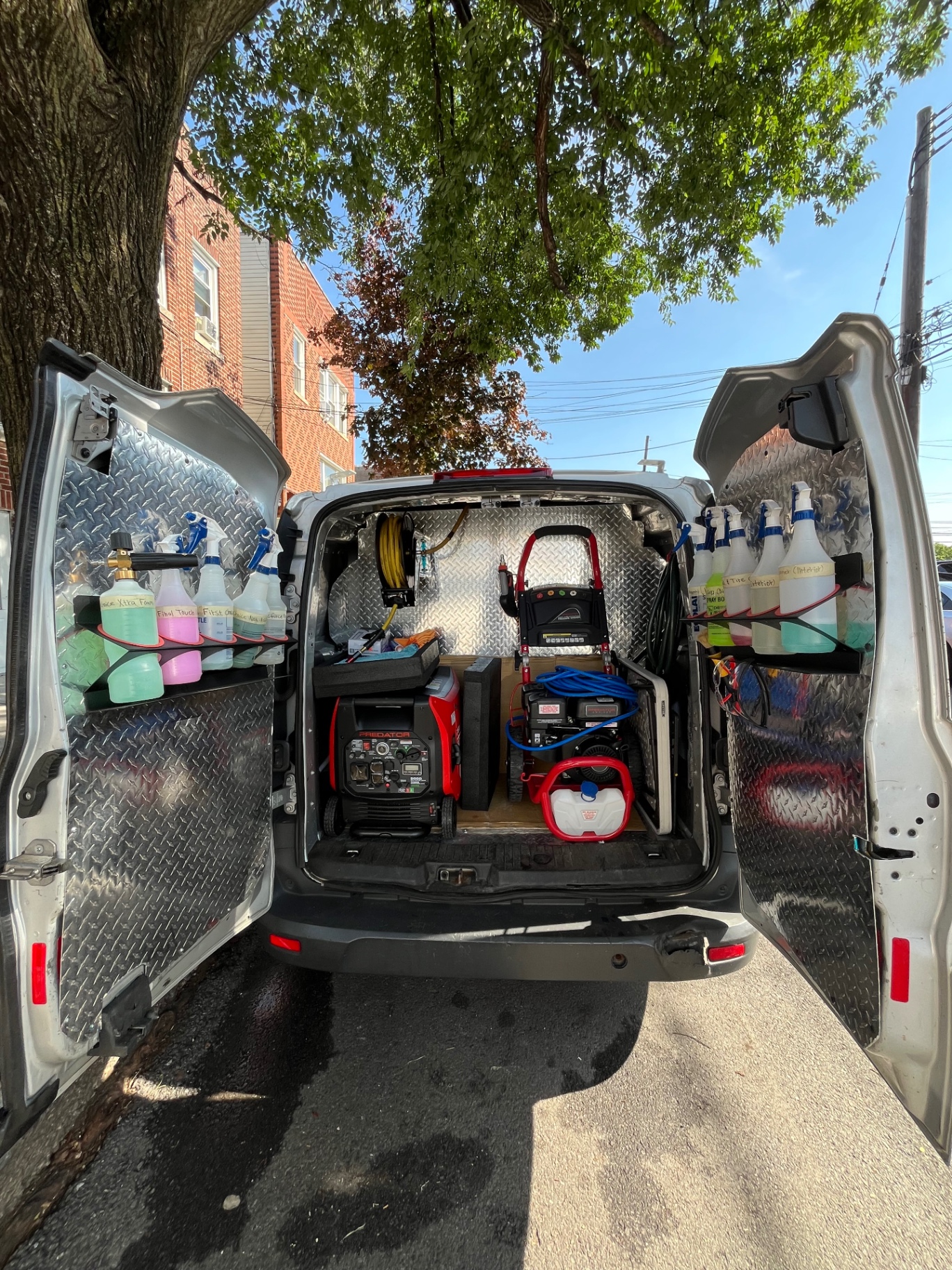 PnP Auto Details mobile detailing van with doors open, shelves of chemicals, generator and pressure washer